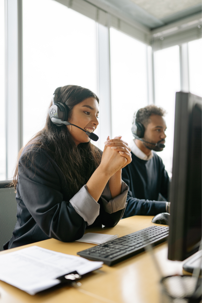 IT Employees with headsets sitting at desktop computers