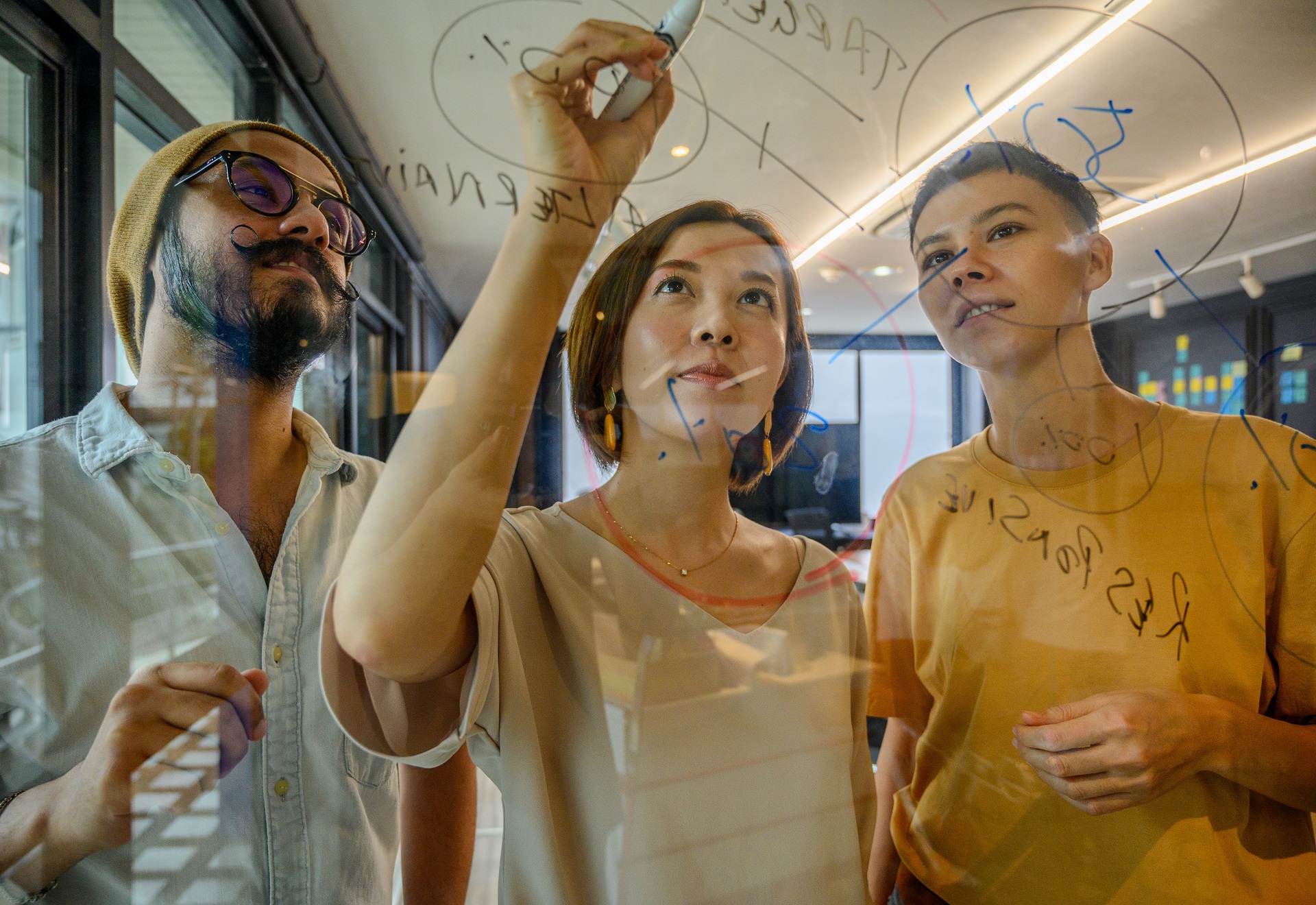 Étudiants qui travaillent sur un tableau de verre