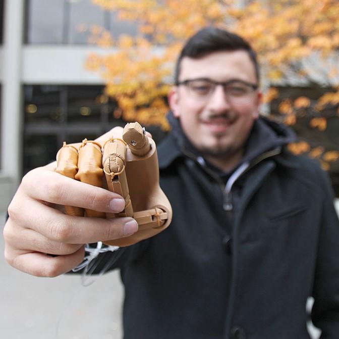 Student point forward for prosthetic hand they built.