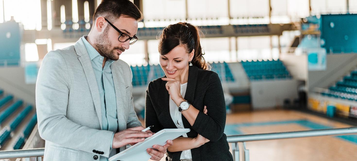 Two people talk in a gymnasium