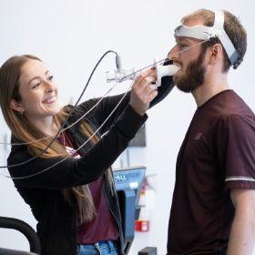 Woman researcher using a breathing apparatus with a man