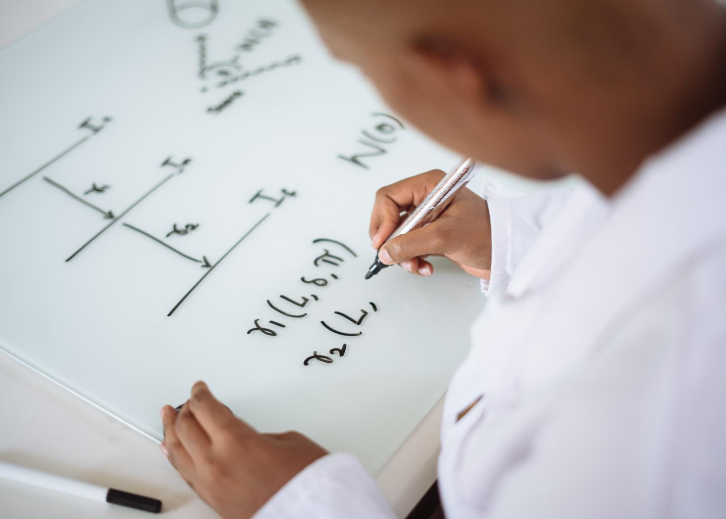 Student writing a mathematical equation