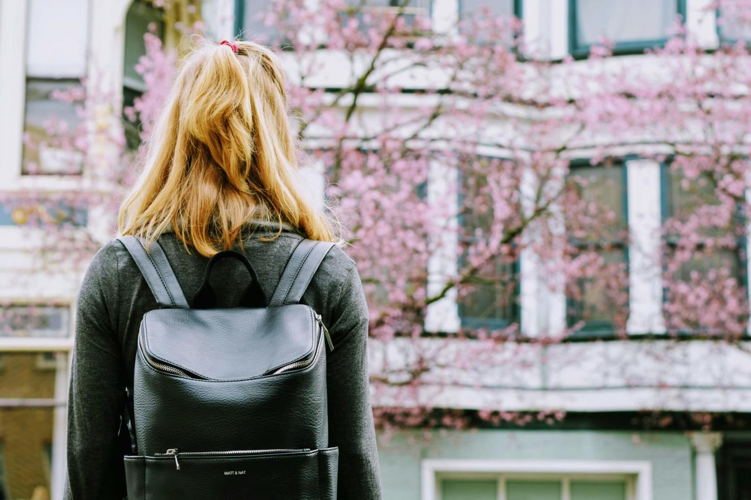 student seen from behind carrying her backpack