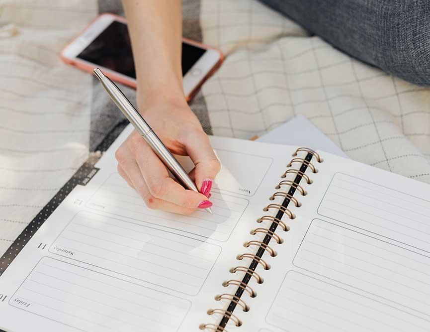 person writing in planner