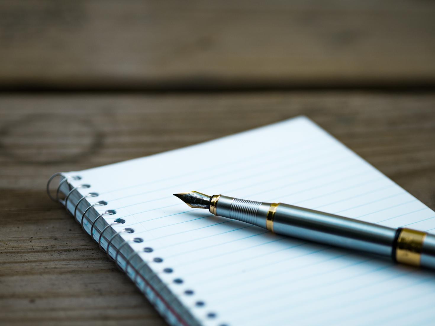 Un cahier avec un stylo au dessus