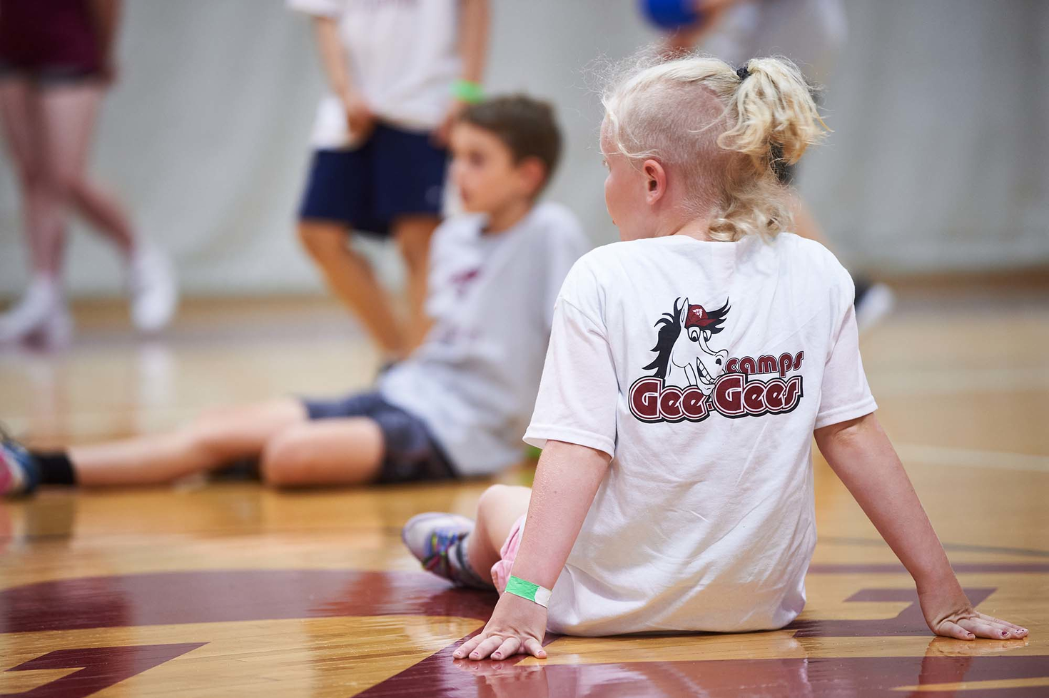 un enfant posé de dos portant un tshirt des camps des Gee-Gees