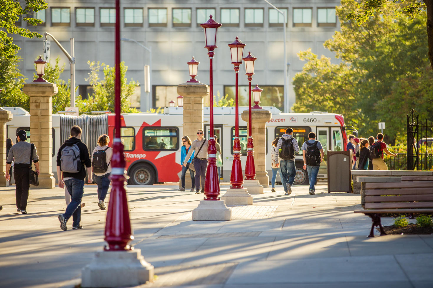 Étudiants marchant sur le campus avec un bus au loin